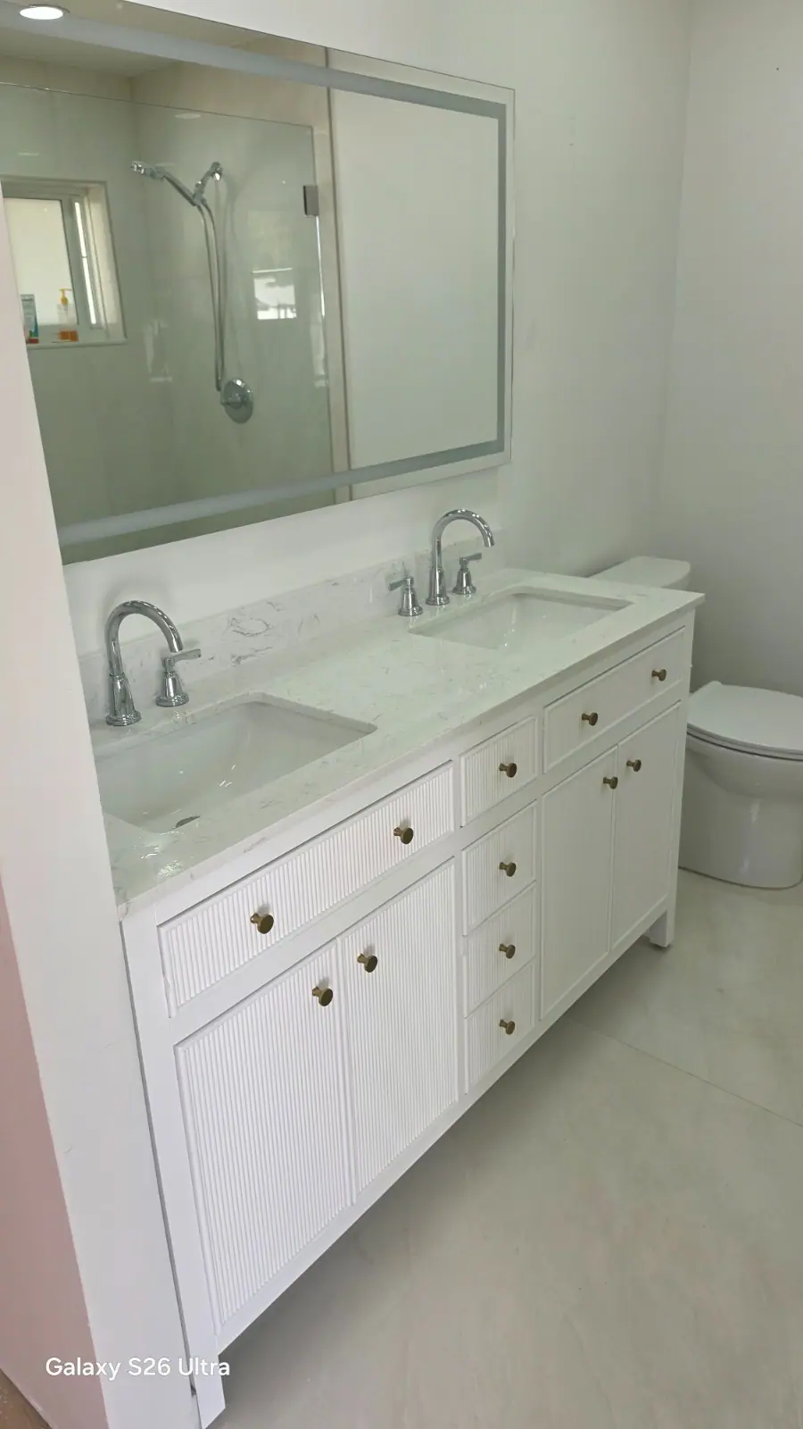 White double vanity with marble countertop and brass hardware