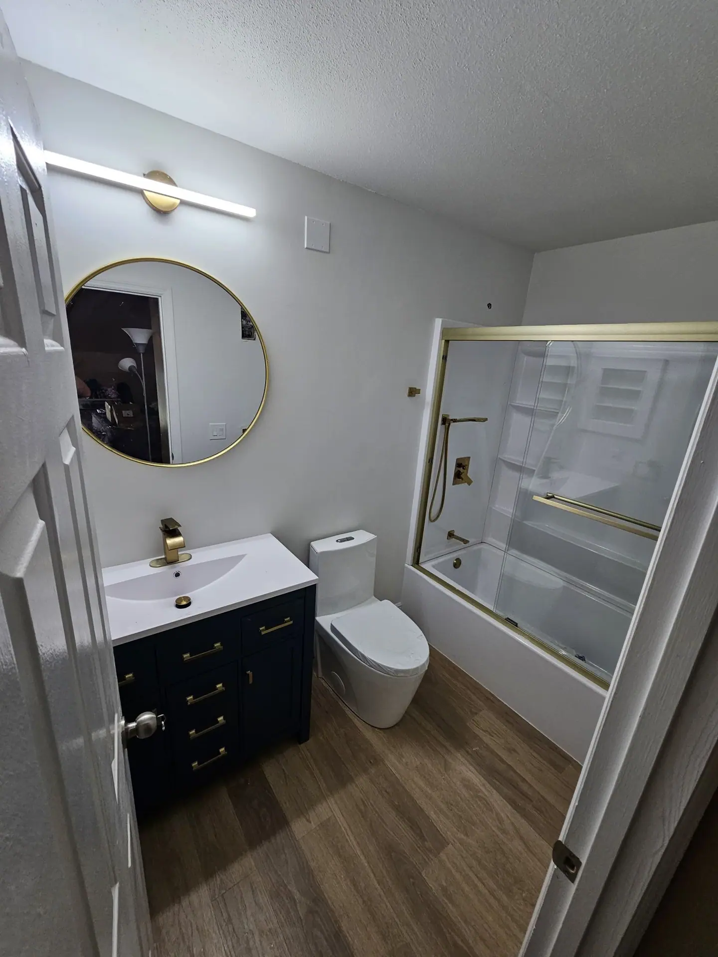 Bathroom with navy vanity and brass fixtures